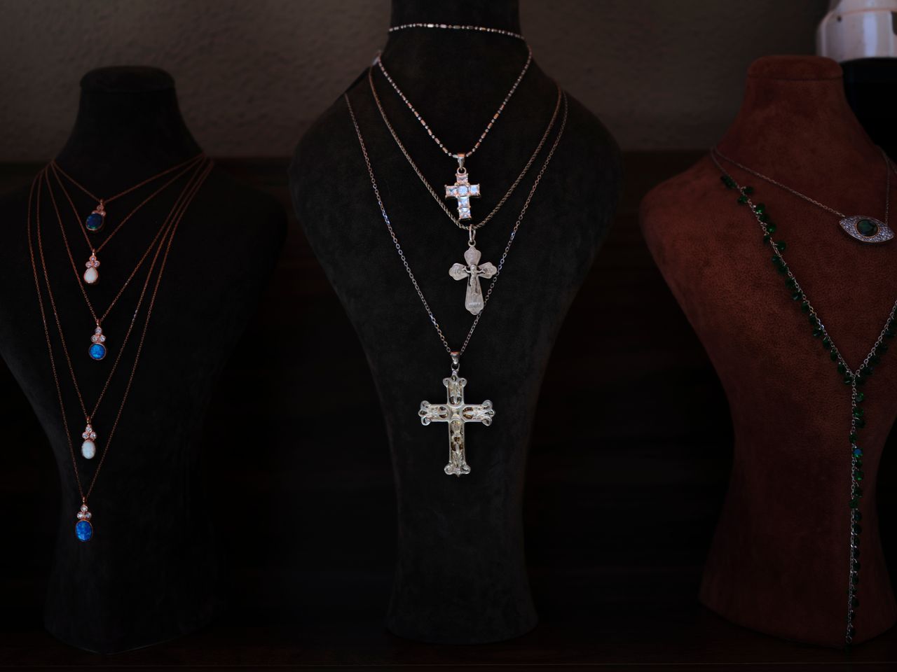 Services Showcase of elegant cross necklaces on velvet display busts. Perfect for religious and jewelry themes.