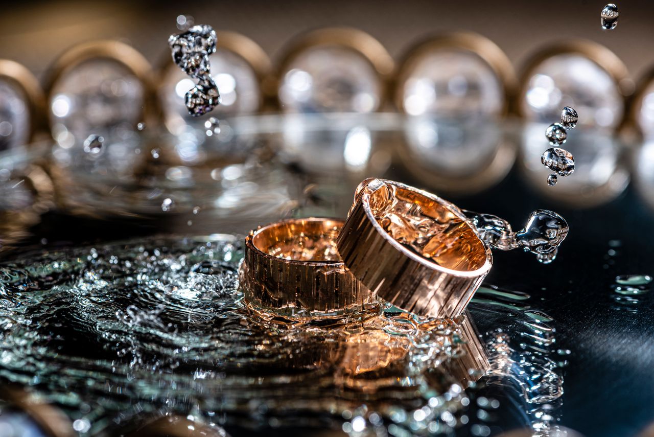 Services Close-up of gold rings with water splashes, highlighting luxury and elegance.