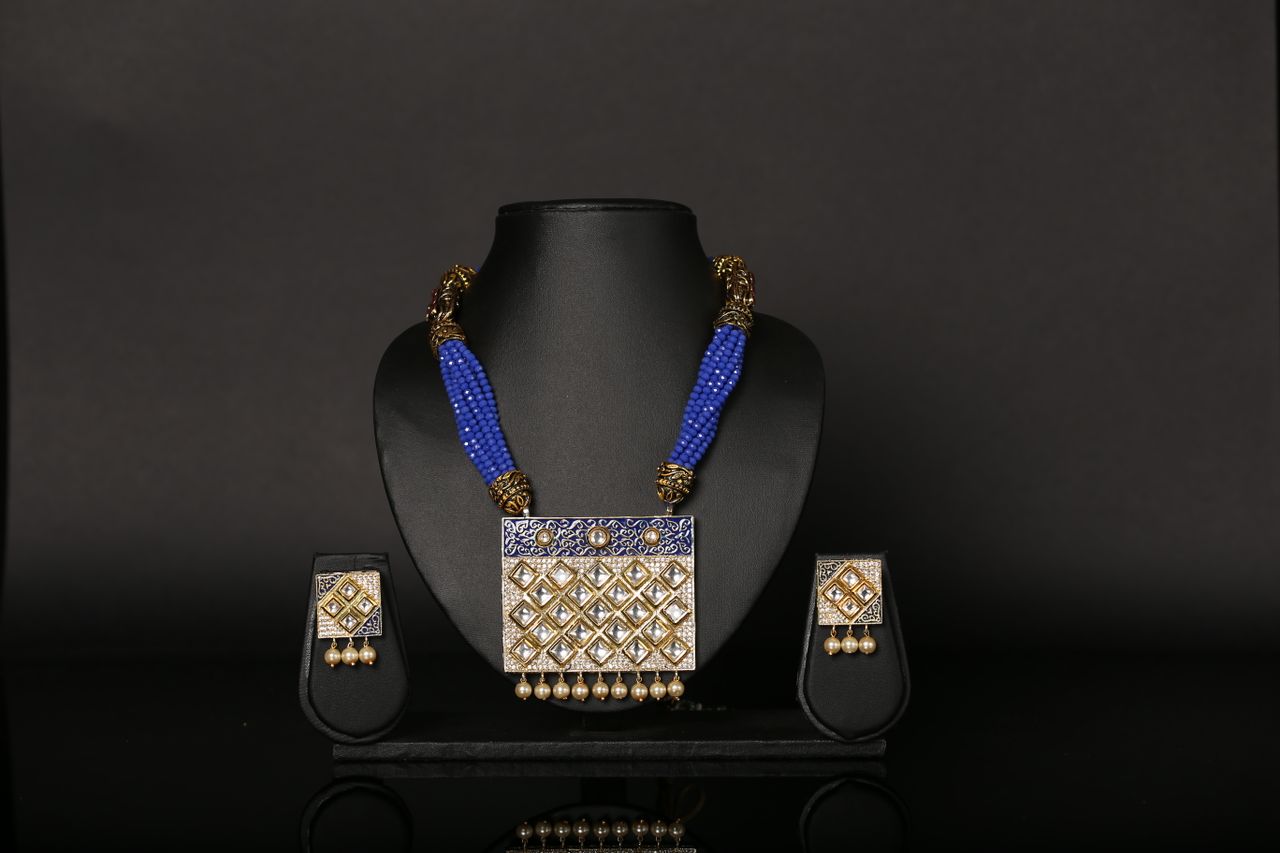 Services Luxury blue beaded necklace and earrings set displayed on a black background, showcasing elegance.