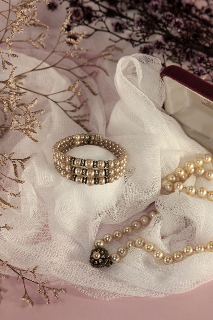 Services Elegant close-up of pearl jewelry arranged on delicate fabric, perfect for fashion and lifestyle themes.